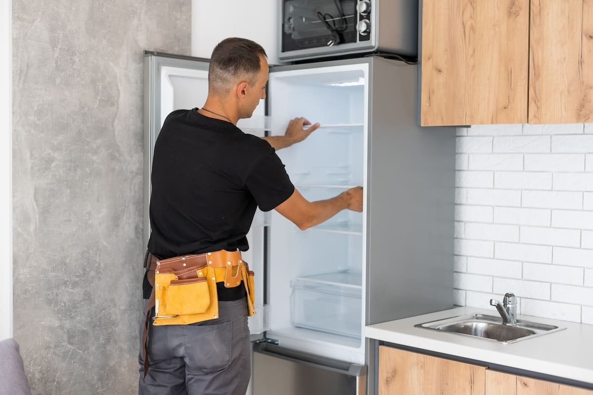 47119574 Young Male Worker Repairing Refrigerator